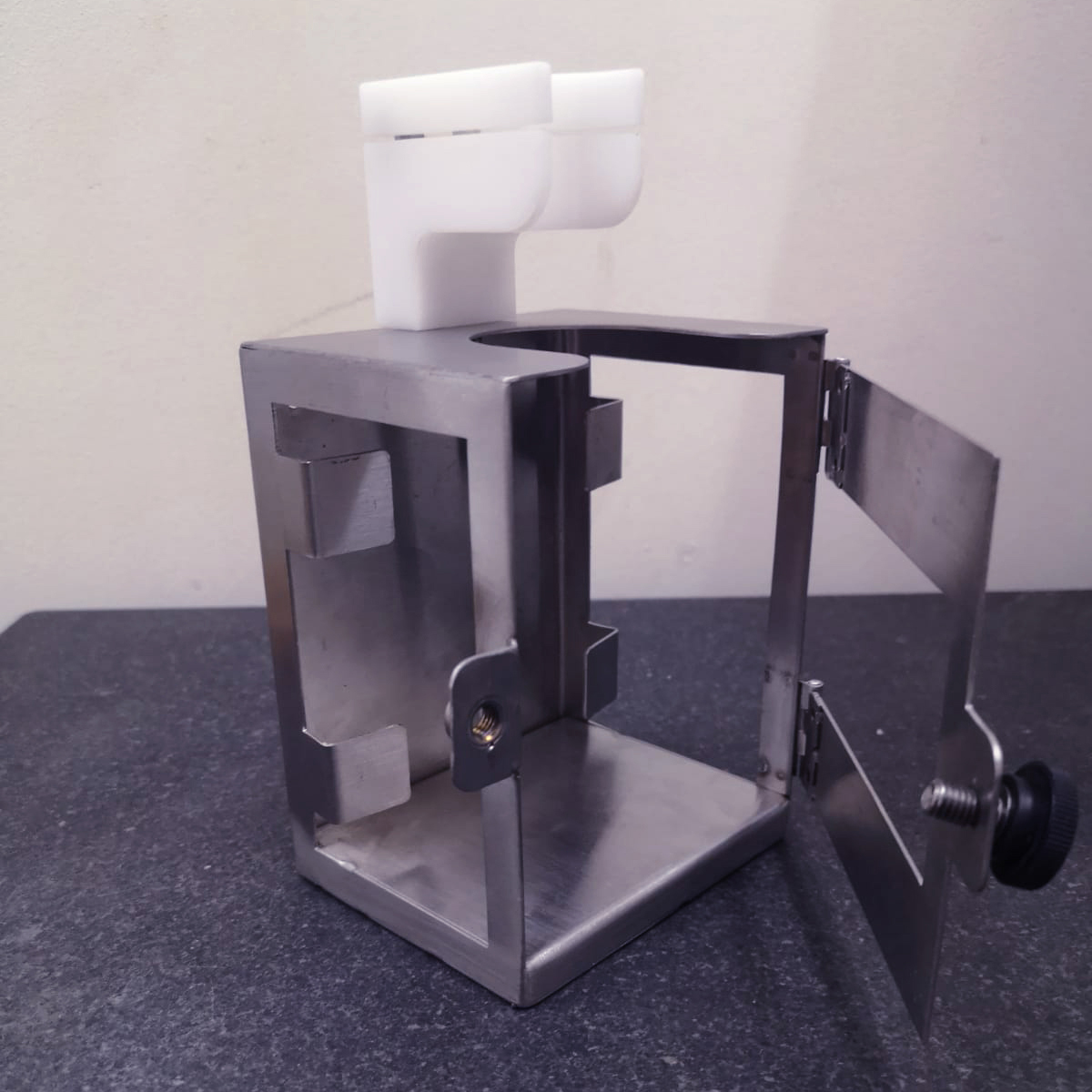 Stainless steel frame designed to fit a hand sanitiser bottle
