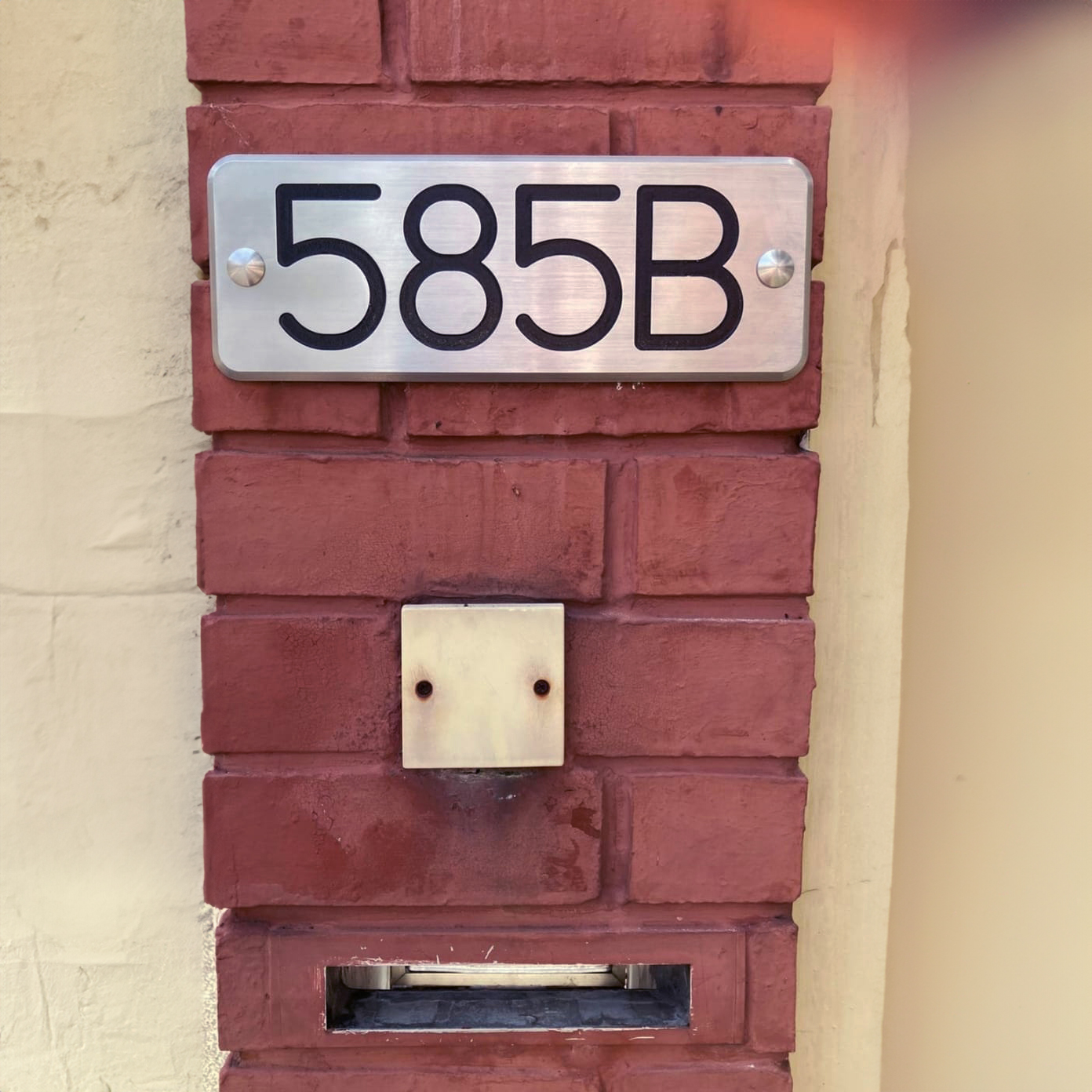 Stainless steel unit number plate outside a house